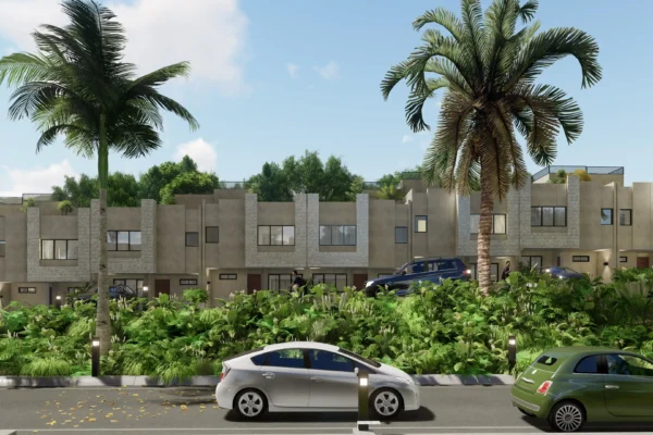 A row of modern townhouses surrounded by tropical plants and palm trees, with parked cars along the street under a bright blue sky.